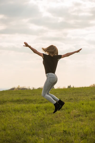 푸른 하늘 위로 점프 하는 행복 한 젊은 여자 — 스톡 사진