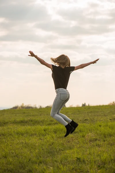 Feliz joven mujer saltando sobre el cielo azul — Foto de Stock