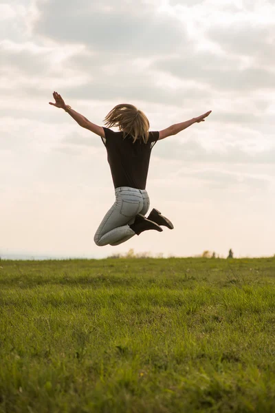 Felice giovane donna saltando sopra il cielo blu — Foto Stock