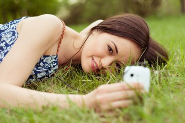 Genç, güzel, gülümseyen kadın cep telefonuyla konuşuyor.