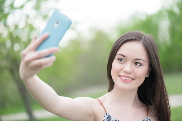 Sorrindo asiático menina tomando auto retrato usando telefone inteligente — Fotografia de Stock