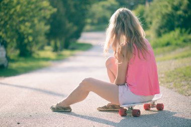 güzel bir genç kadın bir kaykay ile poz