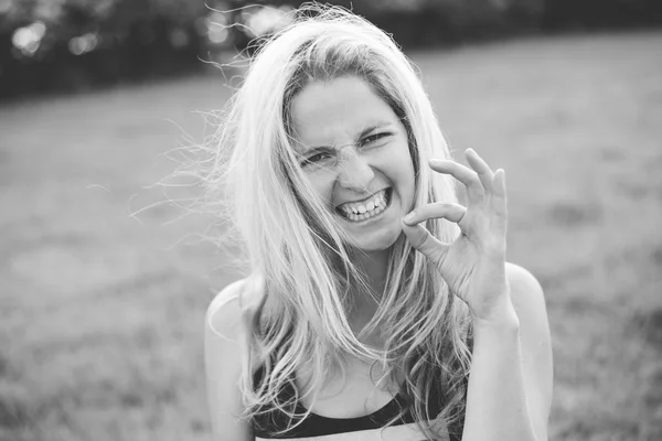 Mujer rubia haciendo muecas al aire libre — Foto de Stock