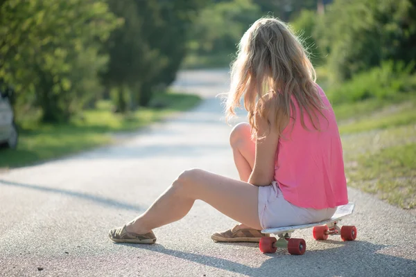 Blonde skateboarder vrouw rusten buiten — Stockfoto