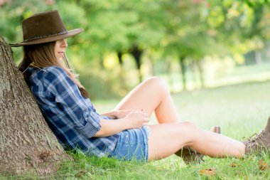 Ağacın altında istirahat şirin kovboy kız