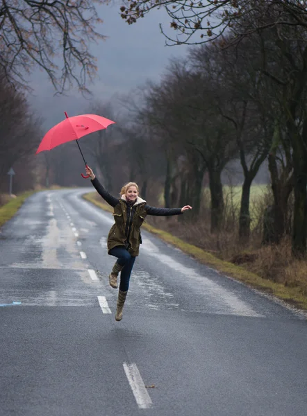 Rainy mulher dia segurando guarda-chuva vermelho — Fotografia de Stock