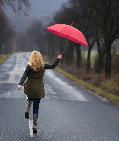 Rainy day woman holding red umbrella — Stock Photo, Image