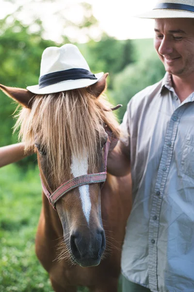 Koně a muž v panama hat — Stock fotografie