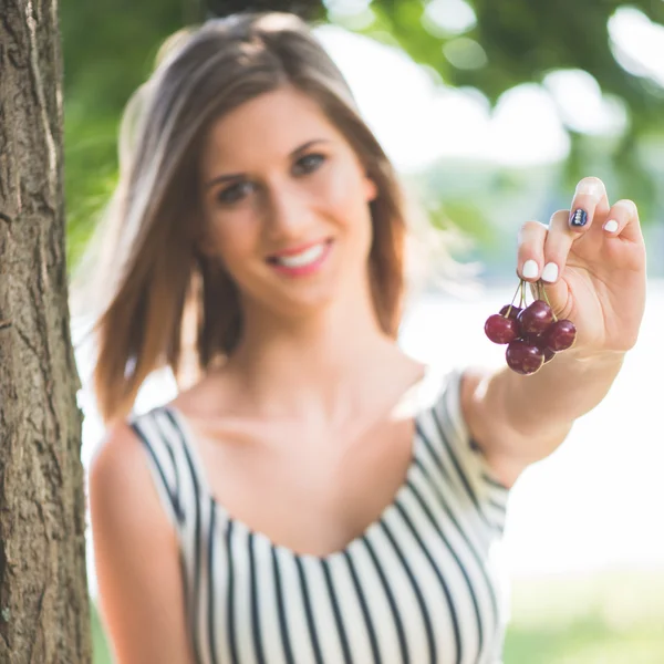 Young woman hlding fresh, ripe sour cherry — Stock fotografie