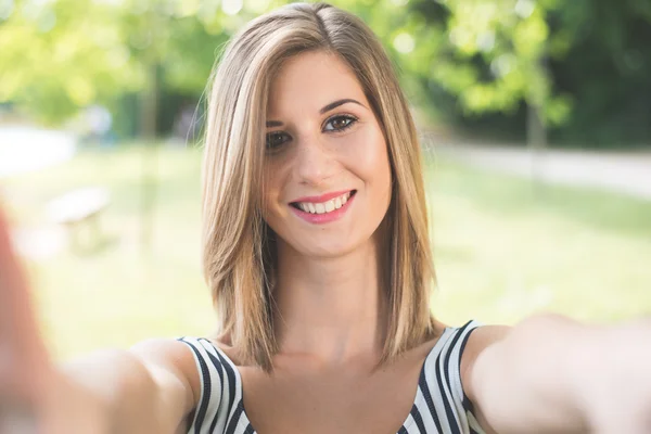 Beautiful young woman making selfie and grimacing — Stock Photo, Image