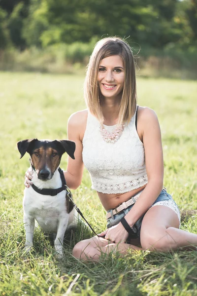 Mujer joven jugando con lindo perro terrier al aire libre en el parque . —  Fotos de Stock