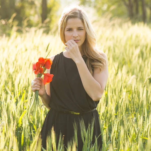 Jovem bela mulher colhendo papoula — Fotografia de Stock