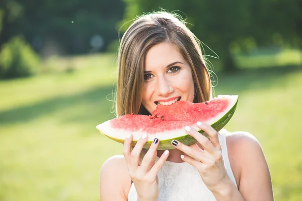 Porträtt av en vacker ung kvinna äta vattenmelon — Stockfoto