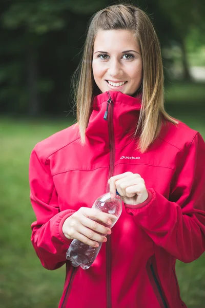 Young woman drinking water after exercise — Stock Photo, Image