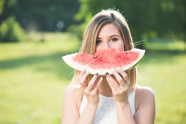 Porträt einer schönen jungen Frau, die Wassermelone isst — Stockfoto