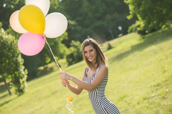 Jovem menina bonita com balões posando ao ar livre — Fotografia de Stock