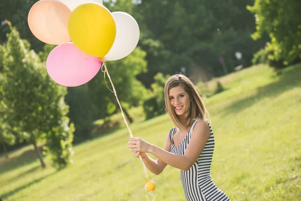 Όμορφη κοπέλα με μπαλόνια που ενέχουν εξωτερική — Φωτογραφία Αρχείου