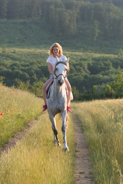 Ung kvinna med häst utomhus — Stockfoto