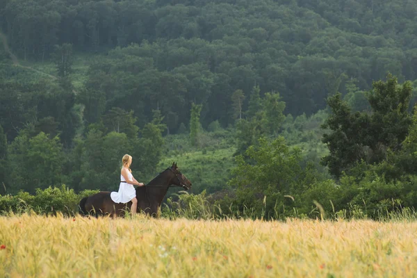 Mujer joven con caballo al aire libre — Foto de Stock