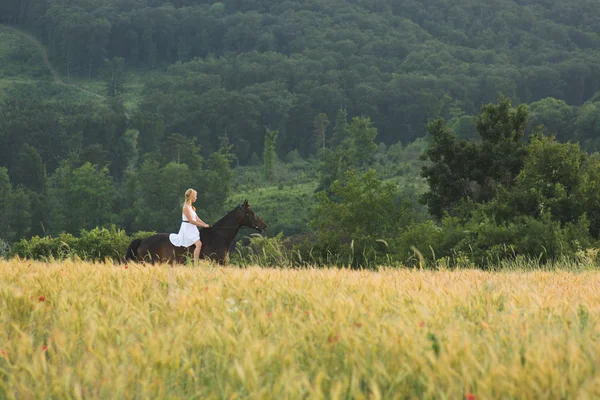 Jeune femme avec cheval en plein air — Photo