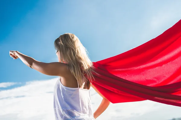 Blonder Superheld fliegt über blauen Himmel und reißt die Arme hoch — Stockfoto