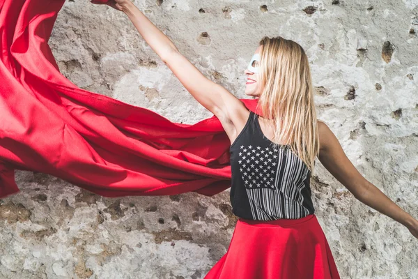 Blonde super hero woman posing with red mantle — Stock Photo, Image