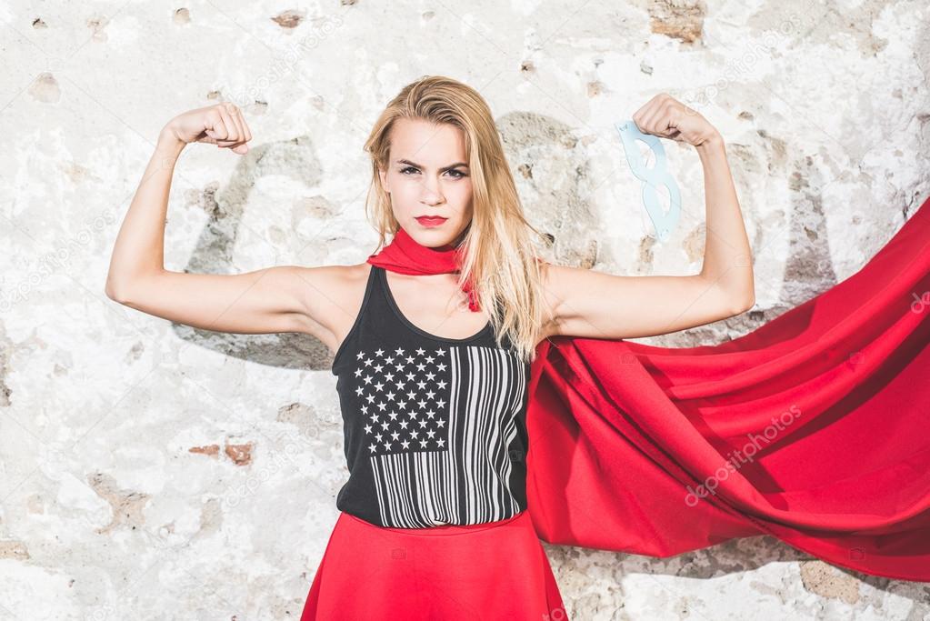 Strong woman posing in front of the camera and shoving biceps