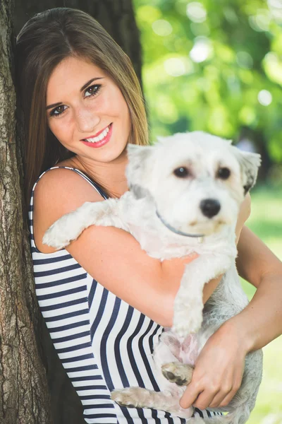 Young cute woman posing with her dog outdoor in the park — 스톡 사진