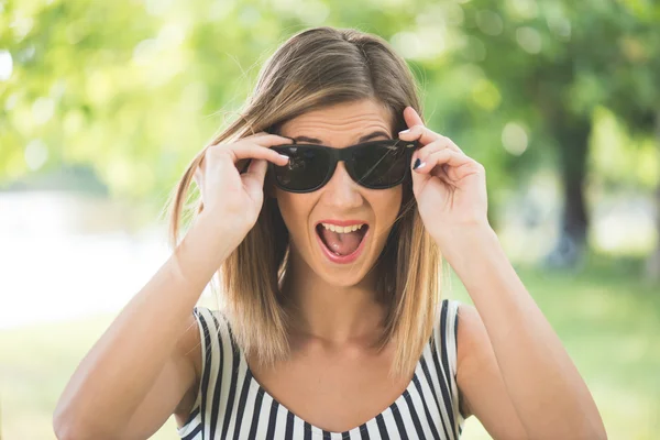 Portrait d'été, jeune femme brune jouant avec ses lunettes de soleil et s'amusant en plein air — Photo