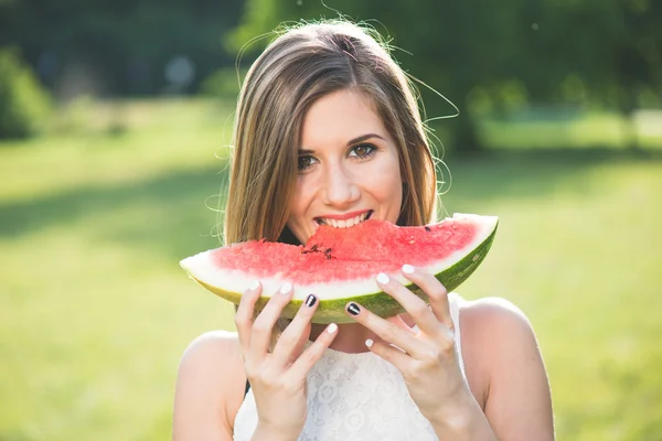 Junge blonde Frau isst frische, saftige Wassermelone — Stockfoto