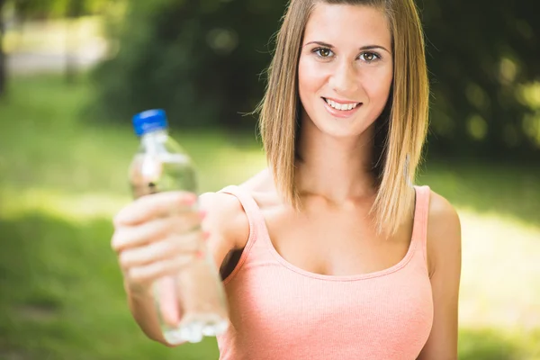 Жаждущая фитнес-девушка с бутылкой воды — стоковое фото