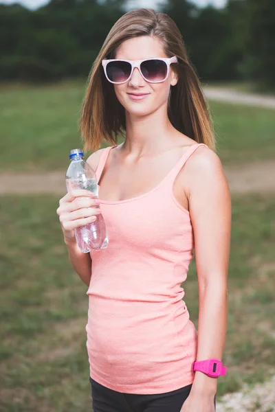 Durstiges Fitness-Girl mit Wasserflasche — Stockfoto