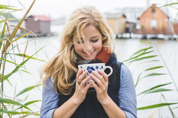 Mujer feliz disfrutando de bebidas calientes — Foto de Stock