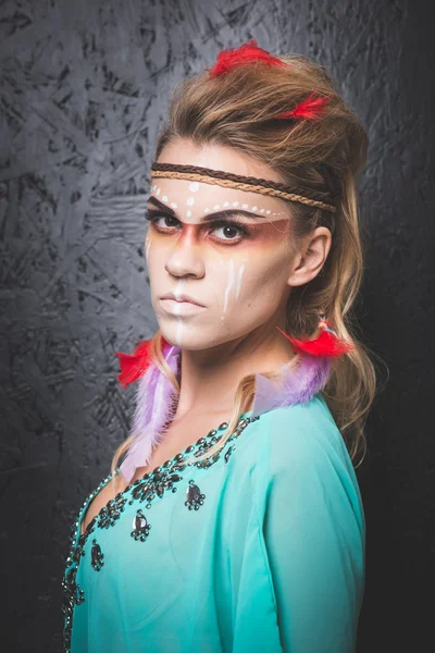 American Indian with paint face camouflage - studio photo with professional makeup