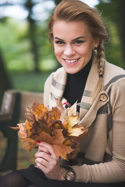 Blondýnka mladá žena držící podzimní listí — Stock fotografie