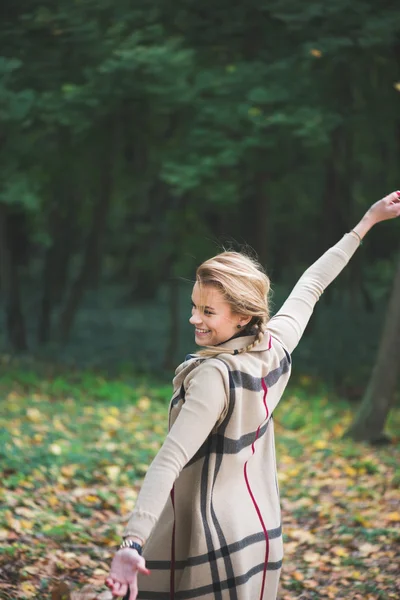 Elegant young woman standing in autumn park outdoor — Stock Photo, Image