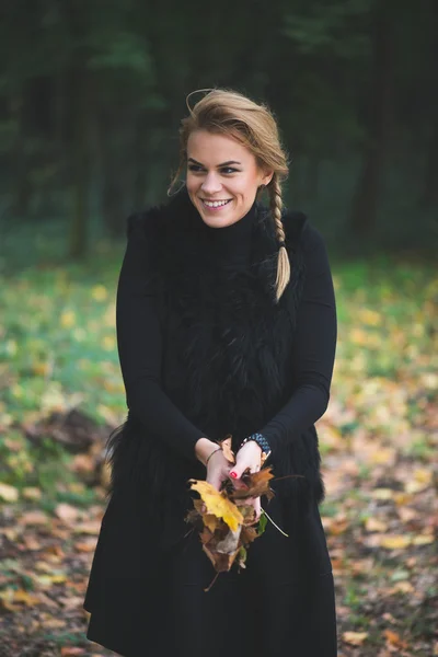 Блондинка молода жінка тримає осіннє листя — стокове фото