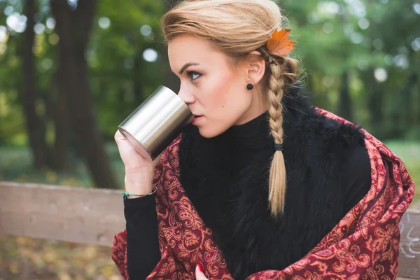 Giovane donna bere tè caldo o caffè all'aperto nel parco autunnale — Foto Stock