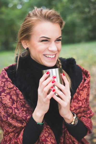 Jovem mulher bebendo chá quente ou café ao ar livre no parque de outono — Fotografia de Stock