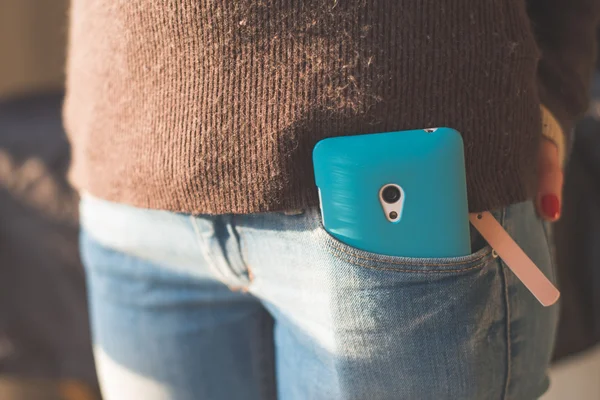 Hipster girl with smartphone in pocket — Stok fotoğraf