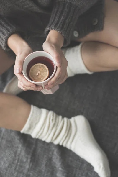 Mladá žena relaxační s šálkem čaje — Stock fotografie