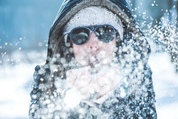 Jovem mulher soprando neve — Fotografia de Stock