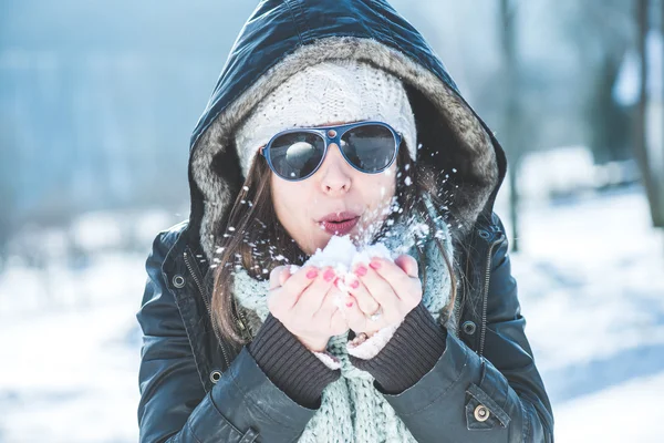 Jovem mulher soprando neve — Fotografia de Stock