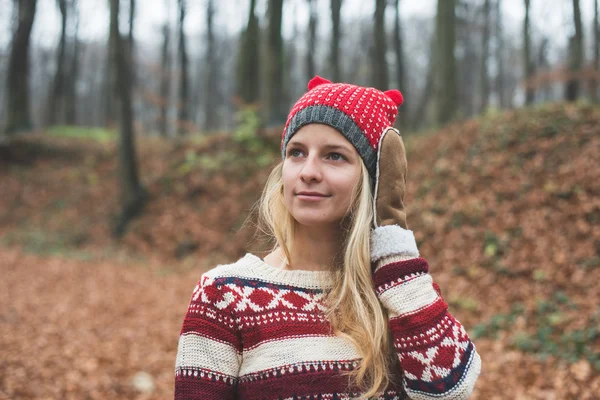 Junge blonde Frau posiert im Freien im Wald und trägt warme Kleidung — Stockfoto
