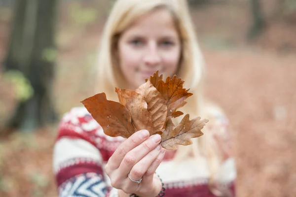 Smiling blonde woman holding leaves — 스톡 사진