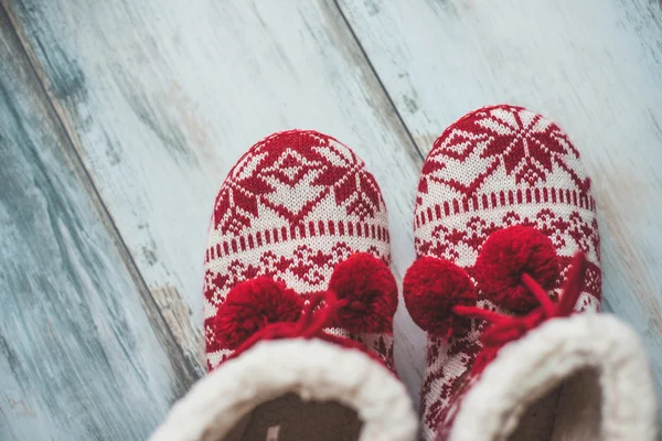 Cozy Christmas slippers on vintage wooden floor