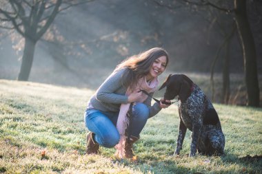 Esmer kadın çok güzel Alman işaretçi köpeğiyle açık poz