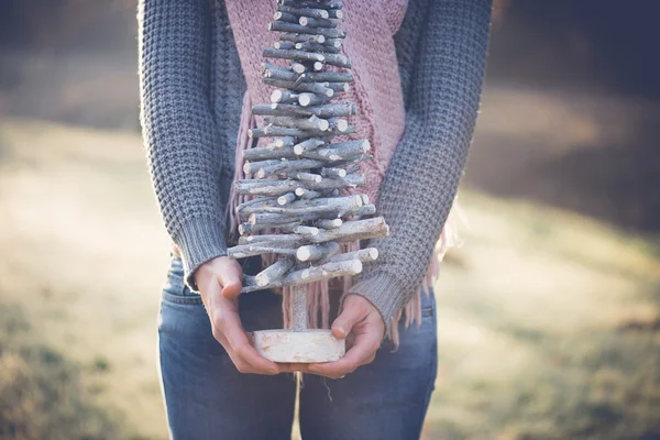 Immagine da vicino di Bruna donna che tiene fai da te decorazione albero di Natale all'aperto — Foto Stock