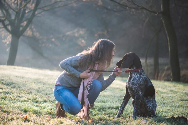 ブルネットの女性は彼女の愛らしいジャーマン ポインター犬を屋外でポーズ — ストック写真