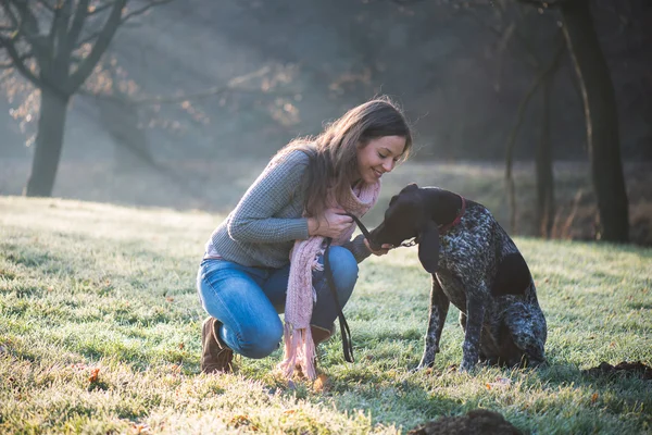 Brunette vrouw poseren met haar schattige Duitse aanwijzer hond buiten — Stockfoto